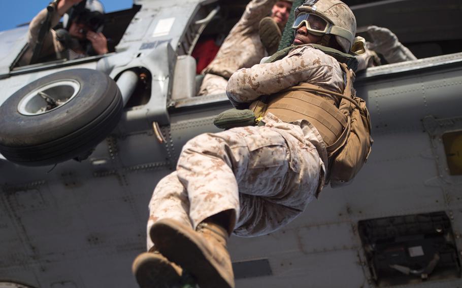 Cpl. Rodrick Huntington, a Marine with company C platoon three of the Fleet Anti-Terrorism Security Team fast-ropes out of an MH-60 Seahawk during training aboard the afloat forward staging base USS Ponce, Sept. 18, 2015.  FAST trains to provide quick-reaction reinforcement of security at U.S. naval and national assets.