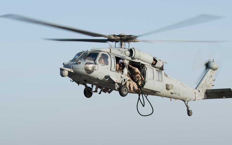 Marines with Company C , 3rd Platoon, the Fleet Anti-Terrorism Security Team, known as FAST, prepare to fast-rope out of an MH-60 Seahawk during training aboard the afloat forward staging base USS Ponce, Sept. 18, 2015.  FAST trains to provide quick-reaction reinforcement of security at U.S. naval and national assets, including U.S. embassies, for a limited duration.  