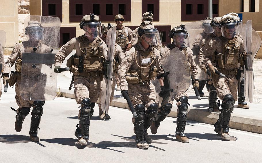 A team of U.S. Marines carrying riot shields rush to secure a defensive line during embassy reinforcement training near Amman, Jordan, April 23, 2018, as part of Exercise Eager Lion 18.