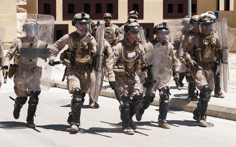 A team of U.S. Marines carrying riot shields rush to secure a defensive line during embassy reinforcement training near Amman, Jordan, April 23, 2018, as part of Exercise Eager Lion 18.  