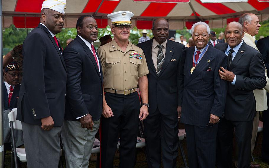 Guests pose with Lt. Gen. Robert F. Hedelund, commanding general, II Marine Expeditionary Force, during the Montford Point Marine Memorial gifting ceremony at the Montford Point Marine Memorial in Jacksonville, N.C., July 25, 2018.