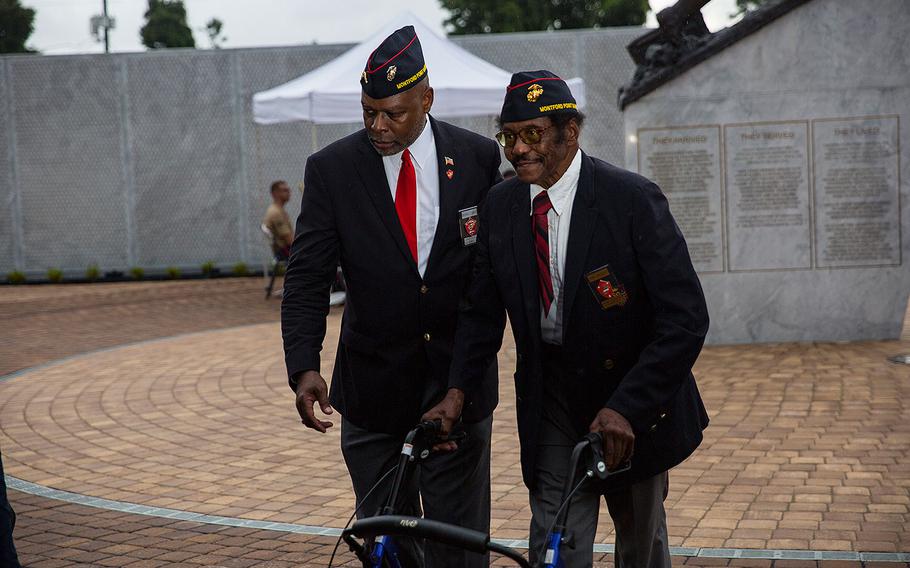 Retired U.S. Marine Col. Grover C. Lewis III, left, escorts, retired U.S. Marine Sgt. John Spencer, right, to his seat during the Montford Point Marine Memorial gifting ceremony at the Montford Point Marine Memorial in Jacksonville, N.C., July 25, 2018.