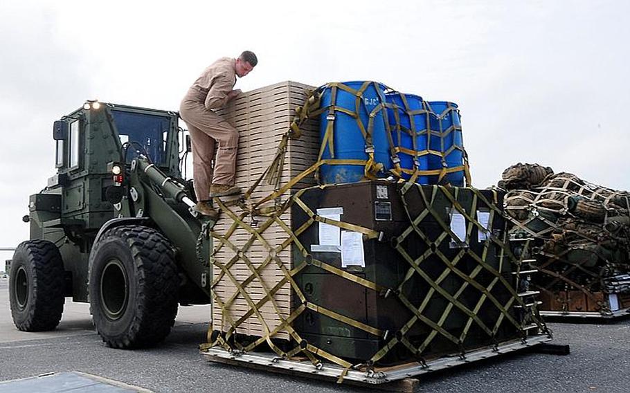 Lance Cpl. Scott Buzzetta ensures that a pallet is correctly fastened for loading onto a Marine Corps C130-J cargo plane Monday. Three Marine Corps C130-J cargo planes left Monday headed for Naval Air Facility Atsugi and Marine Corps Air Station Iwakuni to assist with humanitarian relief efforts.