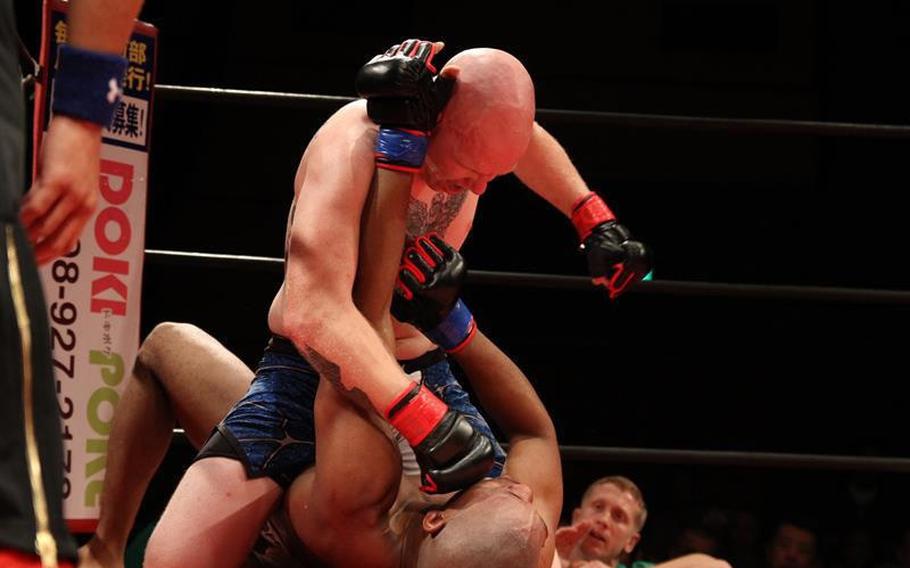 Jessie Frields, a fighter for Military Alliance Fight Team 'grounds and pounds' his opponent during a recent mixed-martial arts fight. Capt. Allen Brittingham, jiujitsu and wrestling coach for Military Alliance, shouts instruction in the background. The Marines have enacted more stringent guidelines on who can and cannot participate in mixed martial arts off-duty as a way to ensure the safety of Marines and sailors, Marine officials said.