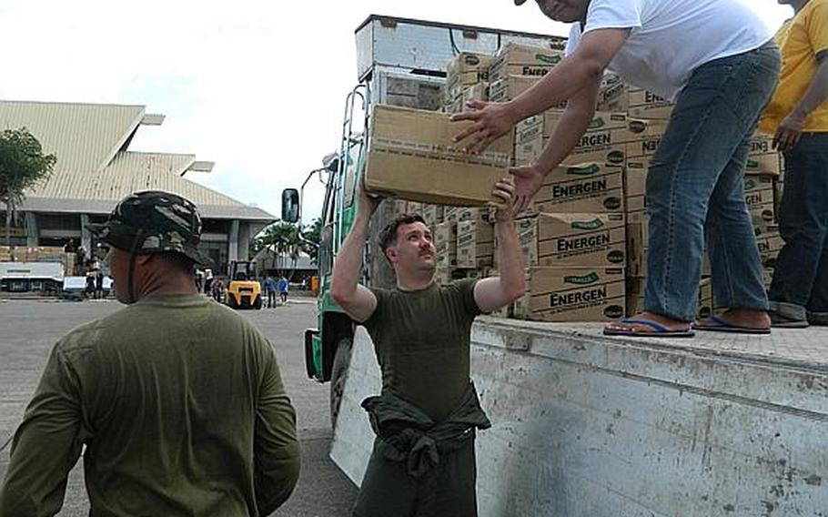 Cpl. Chris Bowen helps off-load relief supplies Dec. 15, 2012, at Davao International Airport, Mindanao, Republic of the Philippines. Bowen is a loadmaster with Marine Aerial Refueler Transport Squadron 152, Marine Aircraft Group 36, 1st Marine Aircraft Wing, III Marine Expeditionary Force.