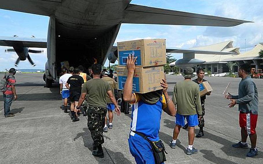 Philippine servicemembers and U.S. Marines off-load relief supplies from a U.S. Marine Corps KC-130J Hercules aircraft Dec. 15, 2012, at Davao International Airport, Mindanao, Republic of the Philippines. The supplies were loaded onto trucks to be taken to a distribution hub where Philippine government and nongovernmental organizations transported them to displaced citizens in need due to the devastation caused by Typhoon Bopha.