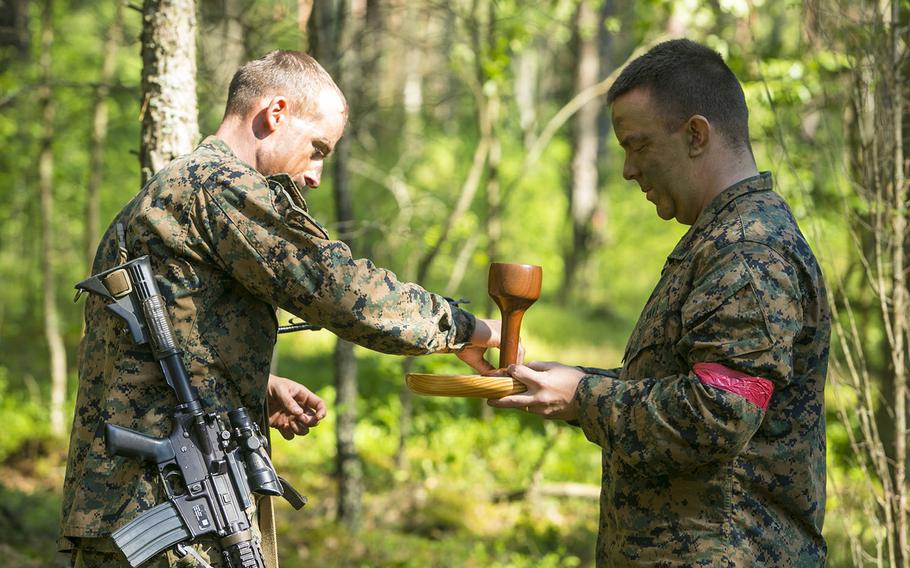Navy Lt. David Jones,chaplain for Marines with Black Sea Rotational Force, provides religious services for troops in the field on the eve of their culminating exercise with partner nations during Exercise Saber Strike at the Pabrade Training Area, Lithuania, on June 14, 2015.