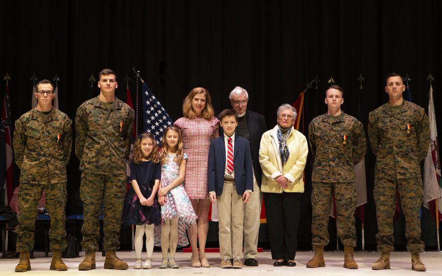 Staff Sgt. Leary Reichartwarfel, left, Sgt. Anders Larson, Cpl. Austin McMullen and Cpl. Timothy Watson pose for a photo with the family they saved after receiving the Navy and Marine Corps Medal at Marine Corps Air Station Cherry Point, N.C., January 28, 2020.