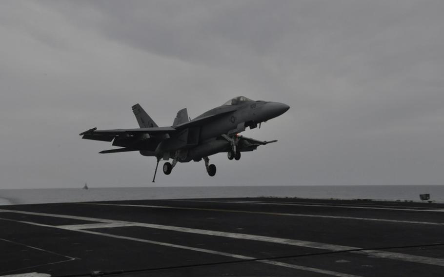 A Navy jet comes in for a landing on the aircraft carrier USS George H.W. Bush on Friday as the ship travels in the Mediterranean Sea.