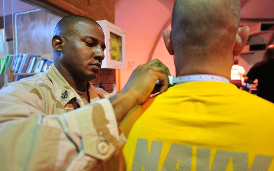 Senior Chief Petty Officer Leo Godet measures the neck of a sailor to check his body composition analysis (BCA) during a physical fitness assessment test at Camp Lemonnier, Djibouti, April 17, 2010.
