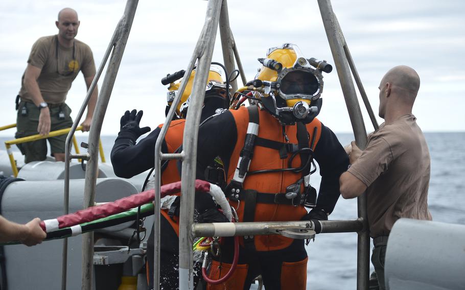 Navy divers wait on the diving stage to be lowered into the water during air surface supplied diving operations off the coast of Virginia. The divers are trying to recover the wreckage of an F-16 Fighting Falcon which crashed Aug. 1, 2013.

