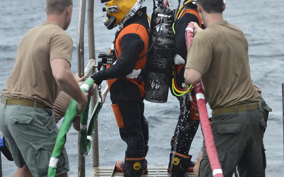 Navy divers are lowered into the water during diving operations off the coast of Virginia to recover the wreckage of an F-16 Fighting Falcon that crashed Aug. 1, 2013. 

