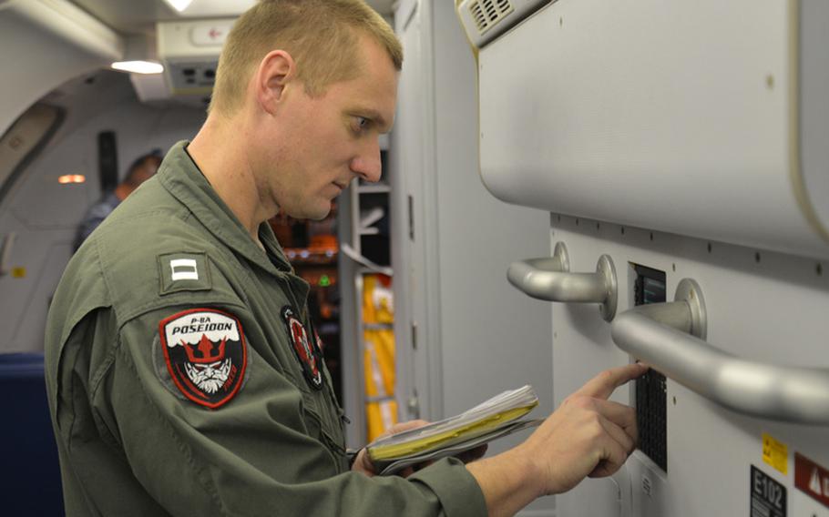 Lt. Joshua Mize, a tactical coordinator assigned to Patrol Squadron (VP) 16, completes his pre-flight checklist in a P-8A Poseidon before a mission to assist in search and rescue operations for Malaysia Airlines flight MH370. VP-16 is deployed in the U.S. 7th Fleet area of responsibility supporting security and stability in the Indo-Asia-Pacific region. 