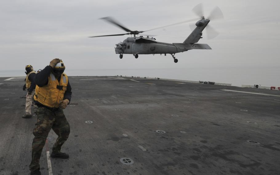 An MH-60S Sea Hawk helicopter lands on the flight deck of the forward-deployed amphibious assault ship USS Bonhomme Richard on April 16, 2014. Sailors and Marines on board Bonhomme Richard have responded to the scene of a sinking ferry near the southwestern coast of the Republic of Korea.  