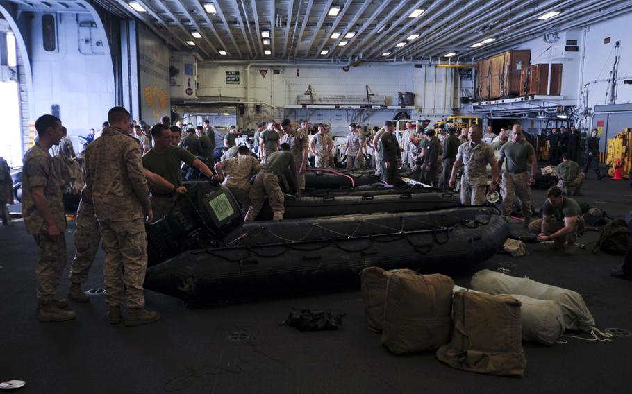 Marines assigned to the 31st Marine Expeditionary Unit prepare combat rubber raiding crafts in the hangar bay of the amphibious assault ship USS Bonhomme Richard on April 16, 2014. 