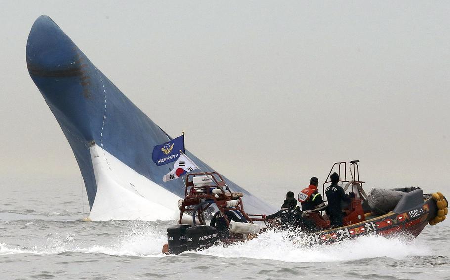 South Korean coast guard officers try to rescue passengers from a ferry sinking in the water off the southern coast near Jindo, south of Seoul, South Korea, on Wednesday, April 16, 2014. 