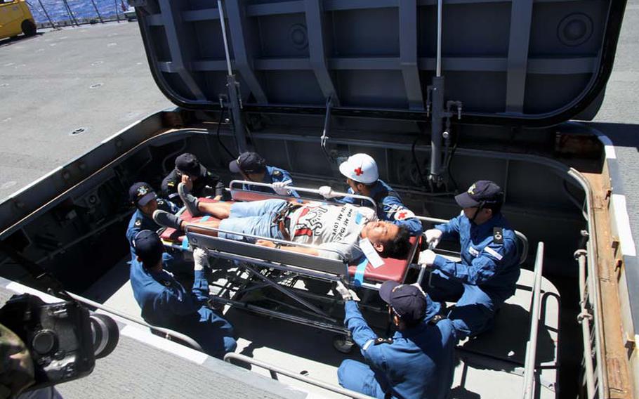 After being airlifted via helicopter to the flight deck of the Japanese destroyer Ise on Saturday, July 12, 2014, a mock victim of a typhoon is lowered on a gurney to the medical ward below. Japan is 1 of 6 nations participating in the disaster relief portion of the Navy's 2014 Rim of the Pacific exercises in Hawaii.