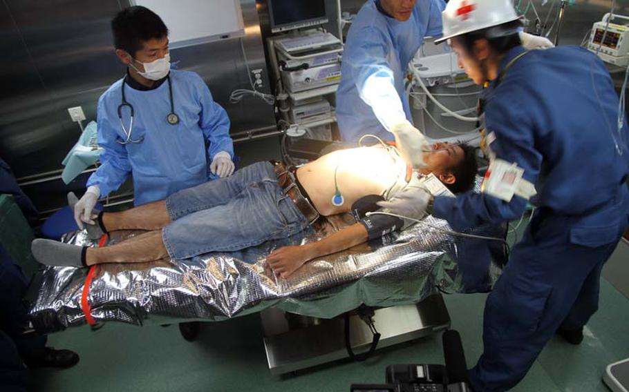 Medical personnel aboard the Japanese destroyer Ise attend to a patient during a mock casualty drill Saturday, July 12, 2014, as part of a Rim of the Pacific exercise. Several 'victims' were airlifted to the ship via helicopters.