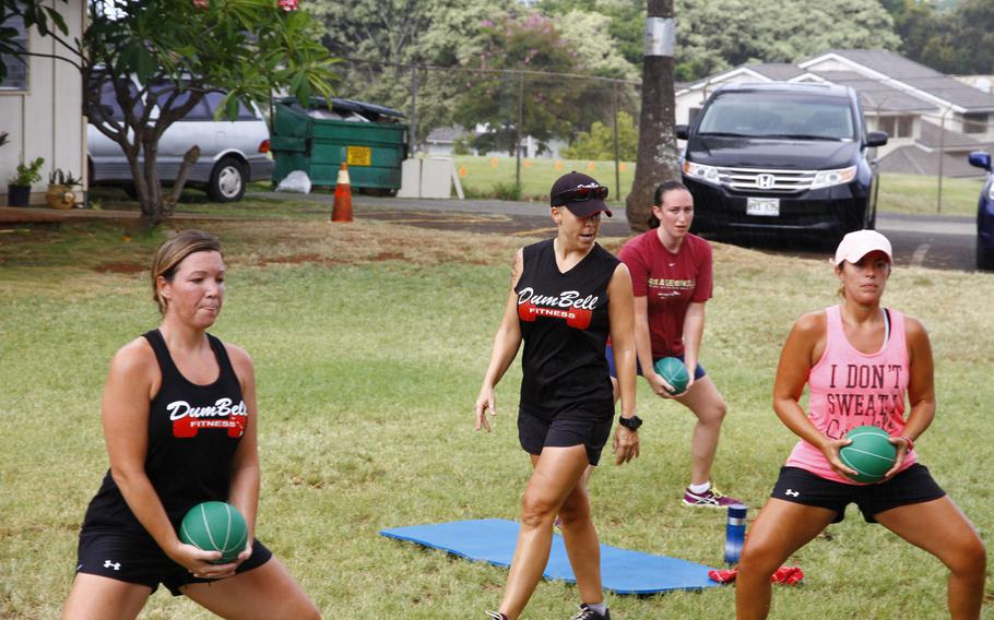 Participants in the Dumbell fitness class perform medicine-ball squats during a recent workout in Hawaii.

