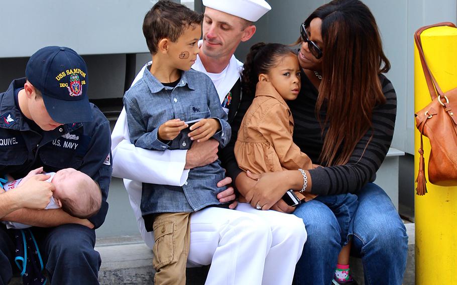 Petty Officer 1st Class Marc Ashby spends time with his children, Johnathan and Veronica, and his fiancee, Madison Miller, at Naval Base San Diego on Friday, Oct. 31, 2014, before leaving for a deployment to the western Pacific.