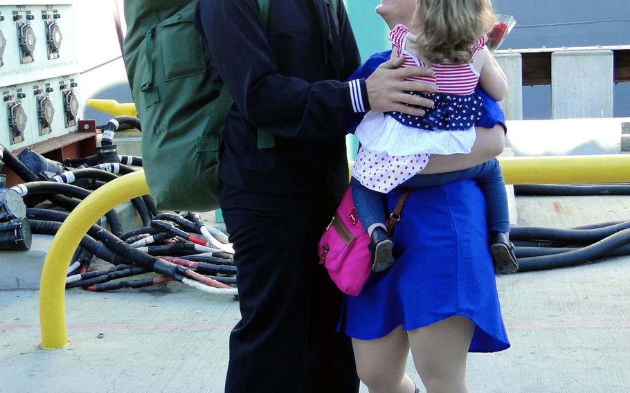 Seaman Richard Gray embraces his wife, Erin, and 1 1/2-year-old daughter, Aria, on Friday, Jan. 16, 2015, at Naval Base San Diego. Gray returned Friday morning from a 7-month deployment to the western Pacific Ocean aboard the USS Cape St. George, a Ticonderoga-class guided missile cruiser.