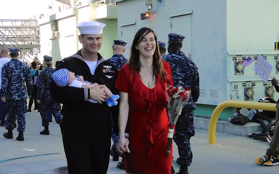 Petty Officer 2nd Class Aaron Hickey and Andee Marotta hold hands as Hickey holds their 1-month-old baby, Tycho. Hickey returned to Naval Base San Diego on Friday, Jan. 16, 2015, after a 7-month deployment to the western Pacific Ocean aboard the USS Cape St. George.