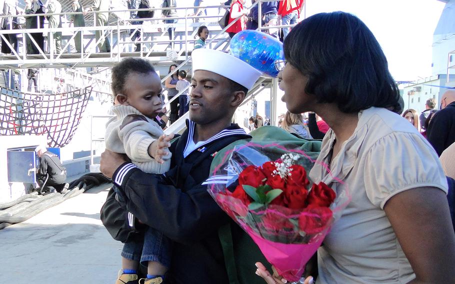 Seaman Dorian Williams holds his 9-month-old baby, Justyn, after returning Friday, Jan. 16, 2015, to Naval Base San Diego from a 7-month deployment aboard the USS Cape St. George. Williams said it felt strange to be home after spending so much time in foreign ports during the ship's deployment in the western Pacific Ocean.