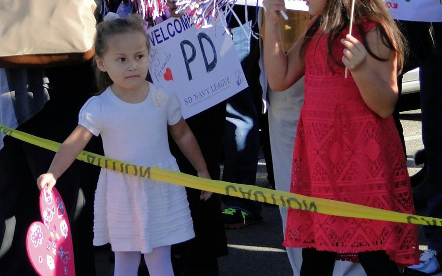 Madison Partida, 3, and Noelani Partida, 6, hold heart-shaped signs as they wait for their daddy, Fernando Alonso Partida, to return from deployment Friday, Jan. 16, 2015. Partida spent about 7 months in the western Pacific Ocean aboard the USS Cape St. George.