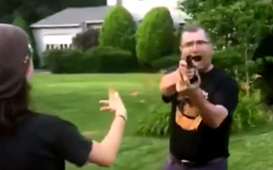 A video screen grab shows Karnig Ohannessian, Deputy Assistant Secretary of the Navy for Environment, pointing a weapon at young people outside his Fairfax, Va., home.