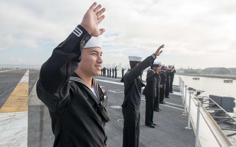 Sailors wave goodbye while manning the rails aboard the aircraft carrier USS John C. Stennis in January. Sailors have been given a one-year extension for receiving extra pay for deployments away from homeport of more than 220 consecutive days.