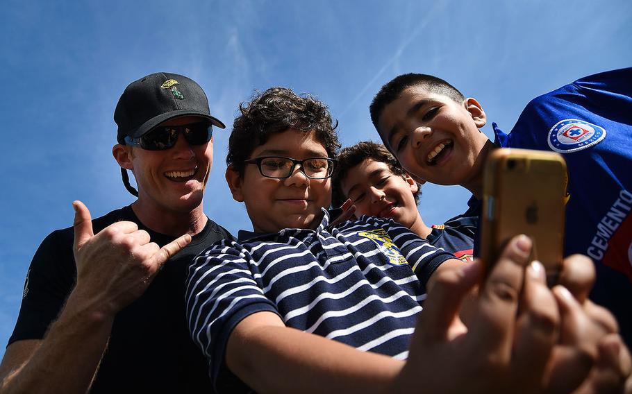 Petty Officer 1st Class Remington Peters, a member of the U.S. Navy Parachute Team “The Leap Frogs,” poses with students for a selfie after a demonstration jump at Hedenkamp Elementary School in Chula Vista, California on March 3, 2016.