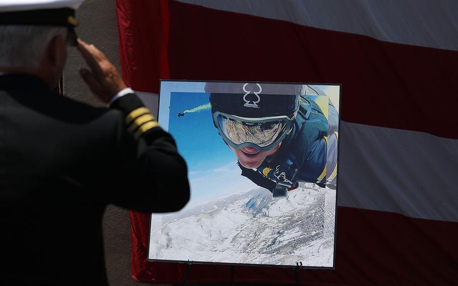 A Navy SEAL salutes a photo of Petty Officer 1st Class (SEAL) Remington Peters during his memorial ceremony at Naval Amphibious Base, Coronado on June 2, 2017. 