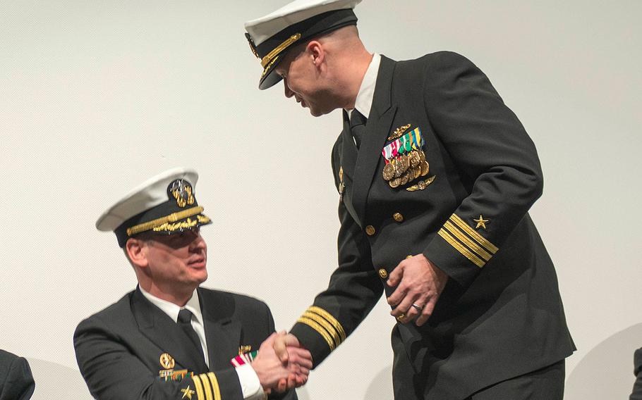 Cmdr. Steven Everhart, standing, shakes hands with Cmdr. John Cage during a change of command ceremony on Jan. 13, 2017 for the Blue crew of the Ohio-class ballistic-missile submarine USS Pennsylvania (SSBN 735).