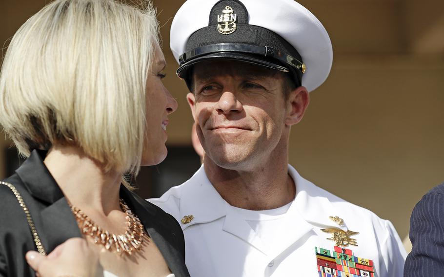 In this July 2, 2019 photo, Navy Special Operations Chief Edward Gallagher, right, walks with his wife, Andrea Gallagher as they leave a military court on Naval Base San Diego, in San Diego.