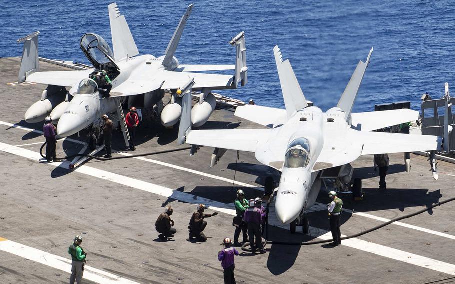In a July 31, 2019 photo, sailors pre-check F/A-18 Super Hornets prior to flight operations on the flight deck of the USS Harry S. Truman during training in the Atlantic Ocean.