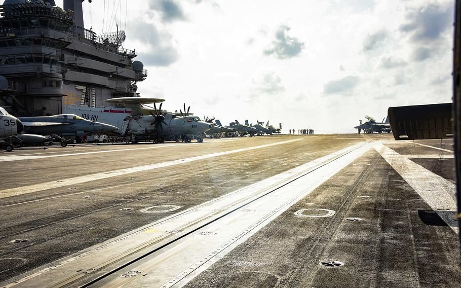 Sailors work on the flight deck of the USS Theodore Roosevelt (CVN 71) March 18, 2020, while transiting the Philippine Sea. On Wednesday, April 1, the Navy said it is working to move most of the crew off the aircraft carrier because of a coronavirus outbreak on the ship.