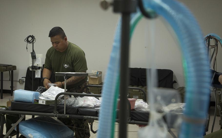 U.S. Navy Petty Officer 3rd Class Adan Trinidad, an intensive care unit medic with 3rd Medical Battalion, 3rd Marine Logistics Group, prepares an intensive care unit bed as part of transitioning an empty building into an operationally capable ICU in order to provide medical support to any USS Theodore Roosevelt sailors in need at Naval Base Guam on April 5, 2020. 