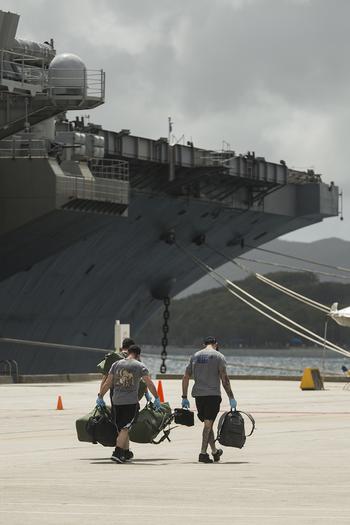 Sailors assigned to the aircraft carrier USS Theodore Roosevelt prepare to embark the ship at Naval Base Guam on April 29, 2020.