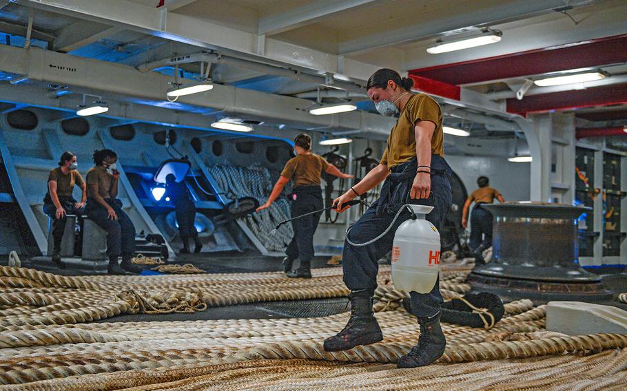 U.S. Navy Boatswain's Mate Seaman Alexis Bias assigned to the aircraft carrier USS Theodore Roosevelt disinfects mooring line on May 21, 2020, following an extended visit to Guam in the midst of the COVID-19 global pandemic. 
