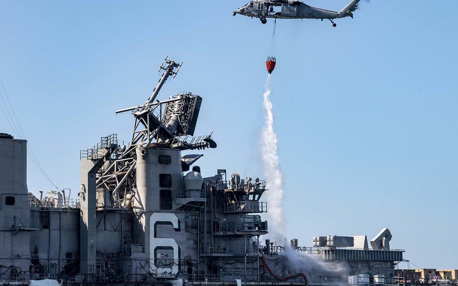 An MH-60S Sea Hawk helicopter from the "Merlins" of Helicopter Sea Combat Squadron 3 provides aerial firefighting support to fight the fire aboard the amphibious assault ship USS Bonhomme Richard.