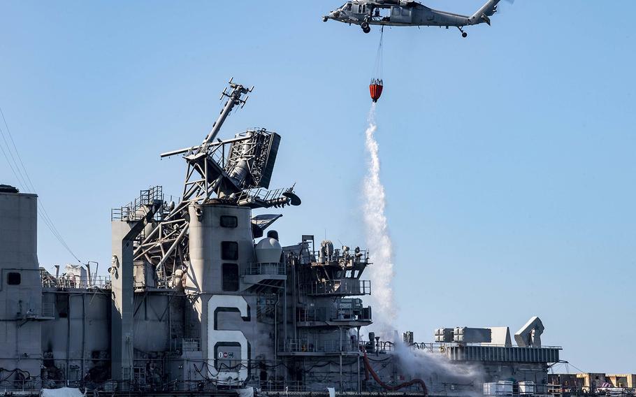 An MH-60S Sea Hawk helicopter from the "Merlins" of Helicopter Sea Combat Squadron 3 provides aerial firefighting support to fight the fire aboard the amphibious assault ship USS Bonhomme Richard. 