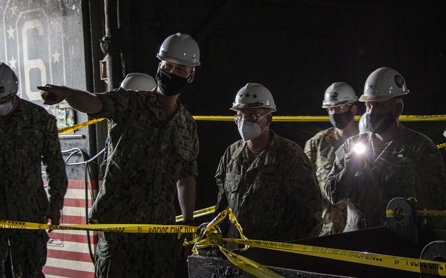 Capt. G.S. Thoroman, left, commanding officer of amphibious assault ship USS Bonhomme Richard (LHD 6) points out fire damage in the hangar bay for Chief of Naval Operations (CNO) Adm. Mike M. Gilday during a visit to the ship on July 17, 2020, to address the crew and assess fire damage.
