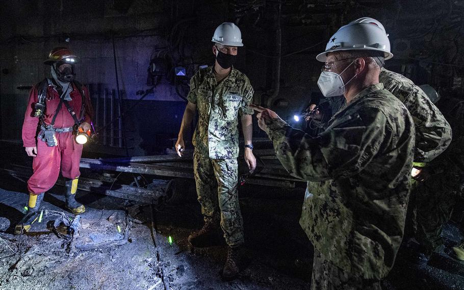 Chief of Naval Operations Adm. Mike Gilday, right, walks through the amphibious assault ship USS Bonhomme Richard (LHD 6) on July 17, 2020, to assess fire damage. 