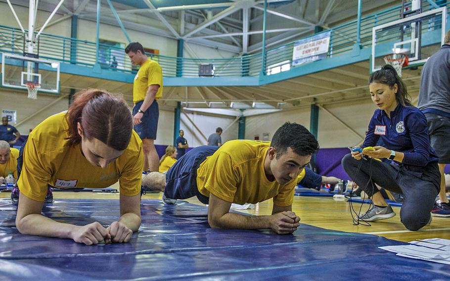 In a March 10, 2020 photo, an instructor explains the proper technique for a plank as part of a Navy Physical Readiness Test Evaluation Phase at Naval Station Norfolk, Va.