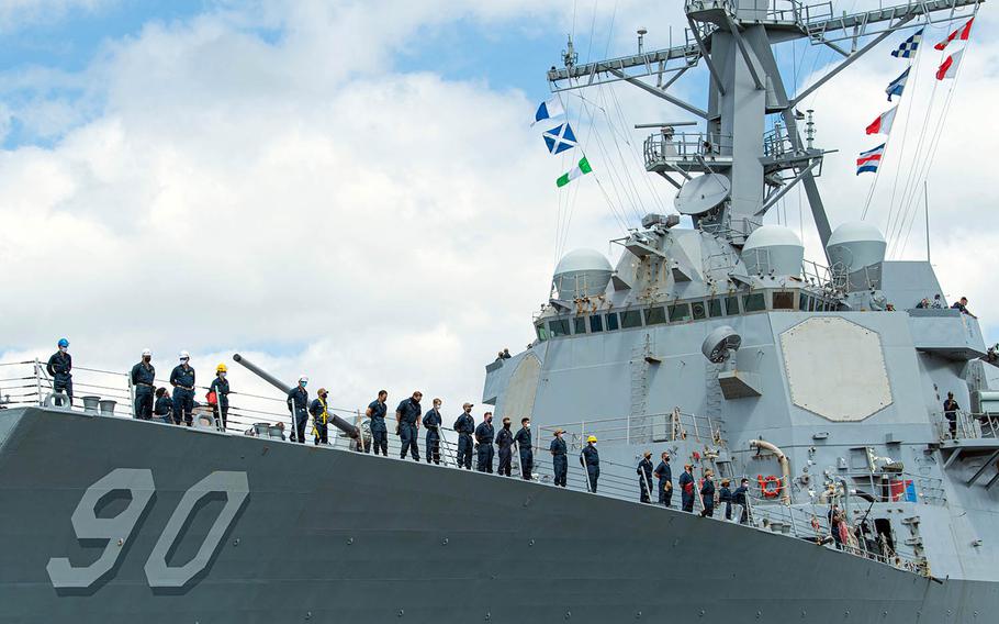 Sailors aboard the guided-missile destroyer USS Chafee man the rails as the ship sails out of Pearl Harbor, Hawaii, July 25, 2020. 