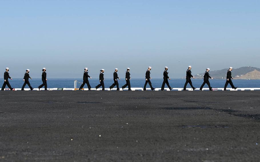 Sailors prepare to man the rails aboard the aircraft carrier USS Nimitz in San Diego, Feb. 26, 2021. 