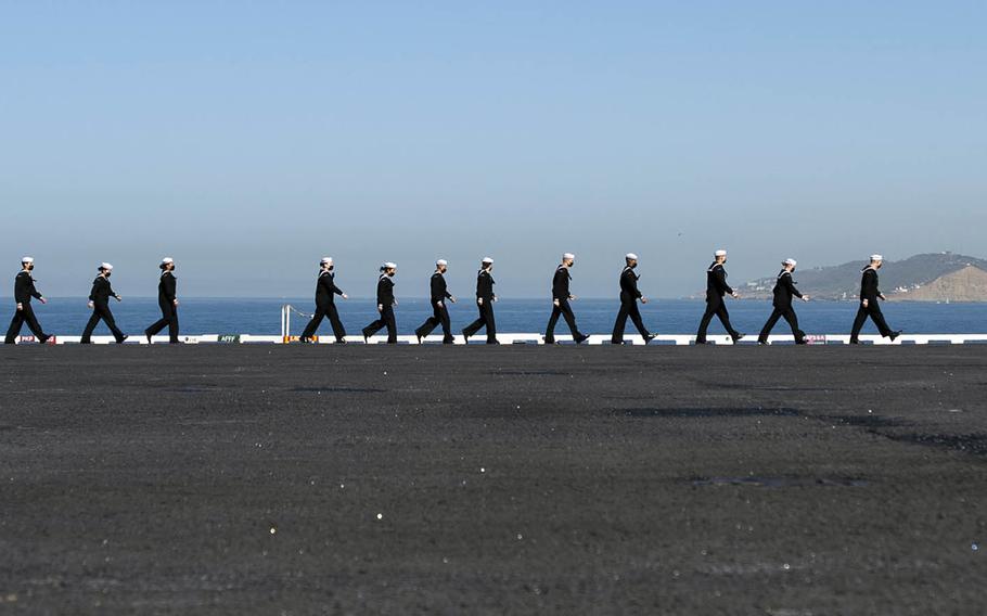 Sailors prepare to man the rails aboard the aircraft carrier USS Nimitz in San Diego, Feb. 26, 2021. 
