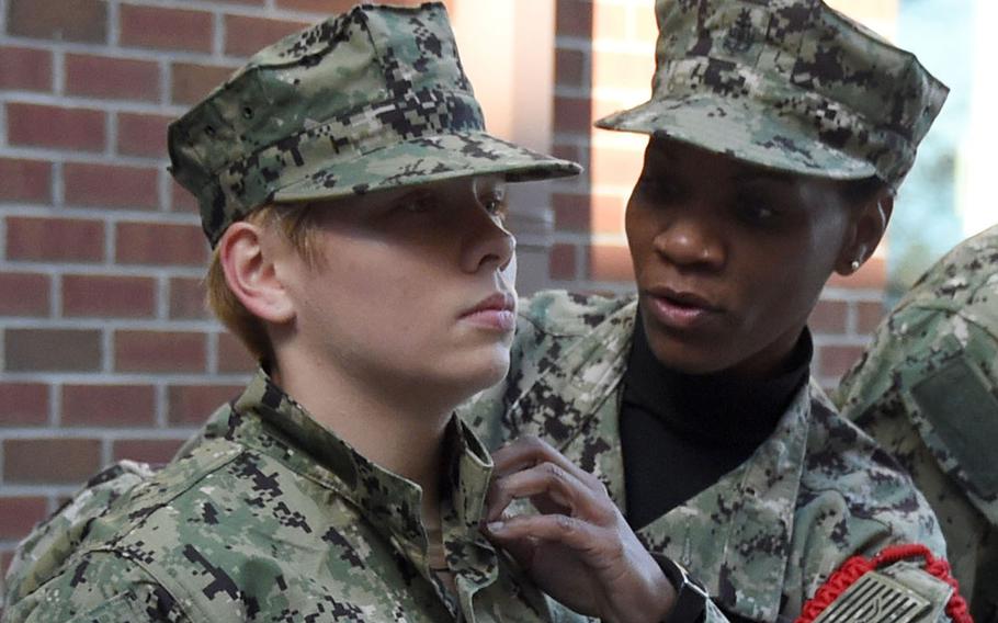 Senior Chief Air Traffic Controller Jacqueline Williams (right), a recruit division commander, wears her working uniform cover as she performs a uniform inspection on an officer candidate in 2017. The Navy is considering changes to where the rank insignia is located.