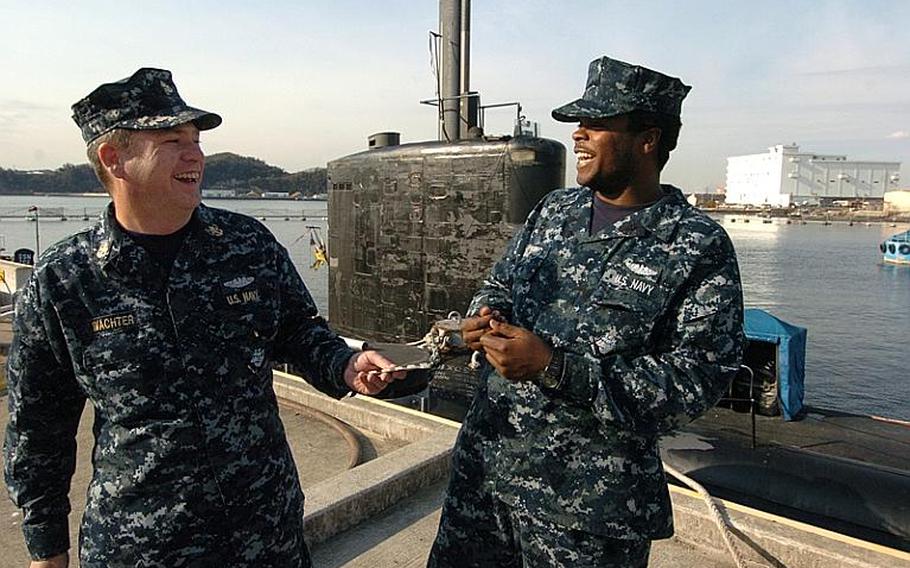 Chief Petty Officer Mark Wachter, left, jokes around while handing out nicotine gum to Seaman Shaquan Topping during a USS Charlotte port visit Thursday at Yokosuka Naval Base, Japan. The Navy banned smoking on submarines as of Jan. 1 due to secondhand smoke exposure. 
