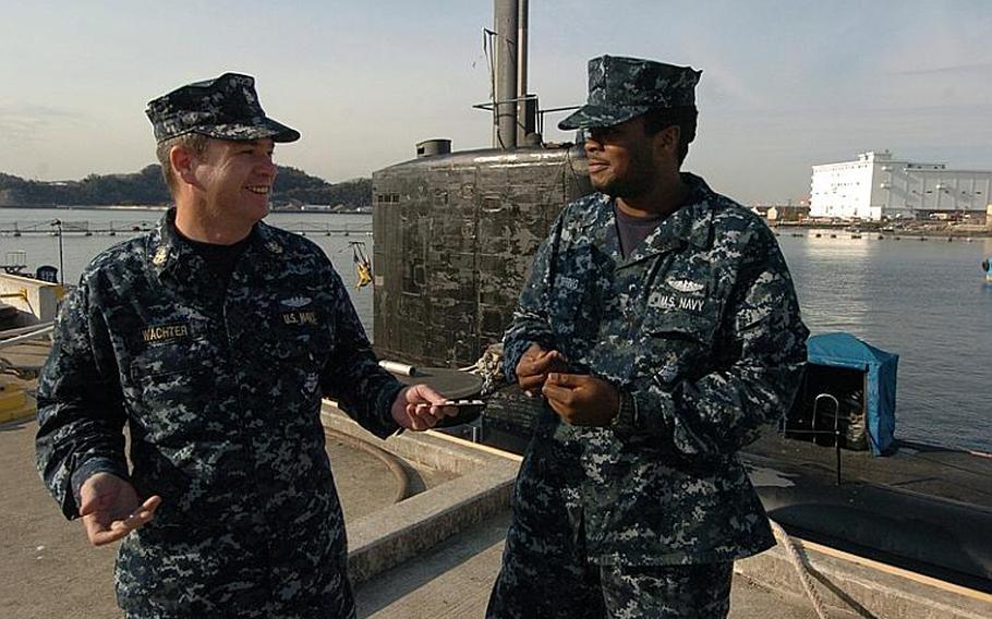 Chief Petty Officer Mark Wachter, left, hands out nicotine gum to Seaman Shaquan Topping during a USS Charlotte port visit Thursday at Yokosuka Naval Base, Japan. The Navy banned smoking on submarines as of Jan. 1 due to secondhand smoke exposure. 
